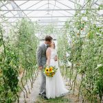 Bride and Groom standing in a green house of greenery