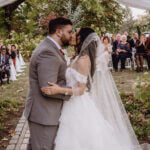 Photo of groom and bride exchanging their first kiss at the altar, with traveling wedding DJ services by Paul Michaels Events
