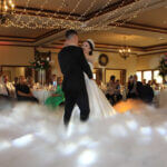 A bride and groom sharing their first dance with a "dancing in the clouds" effect, courtesy of the premium DJ services from Paul Michaels Events