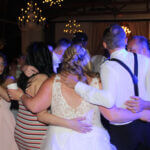 A group circle formed with a bride and groom forming part of the circle, swaying to the sounds of the best Illinois wedding entertainment DJ, Paul Michaels Events