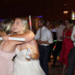 A bride hugging one of her bridesmaids in the middle of the dance floor, dancing the night away to one of the best Chicagoland wedding entertainment DJs, Paul Michaels Events