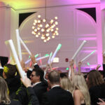 Group of people waving glow sticks on the dance floor