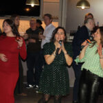 Group of ladies singing karaoke at corporate holiday party