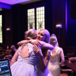 Bride and guest hugging on the dance floor with music