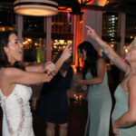 Bride and bridesmaid dancing to music on the dance floor