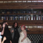 Bride and groom on the dance floor with friends.